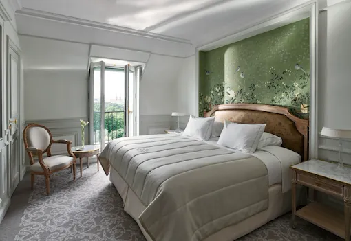 Bedroom side of the superior room, with a green hand painted wall and the view on the Tuileries Garden in the distance. At Le Meurice, Paris.
