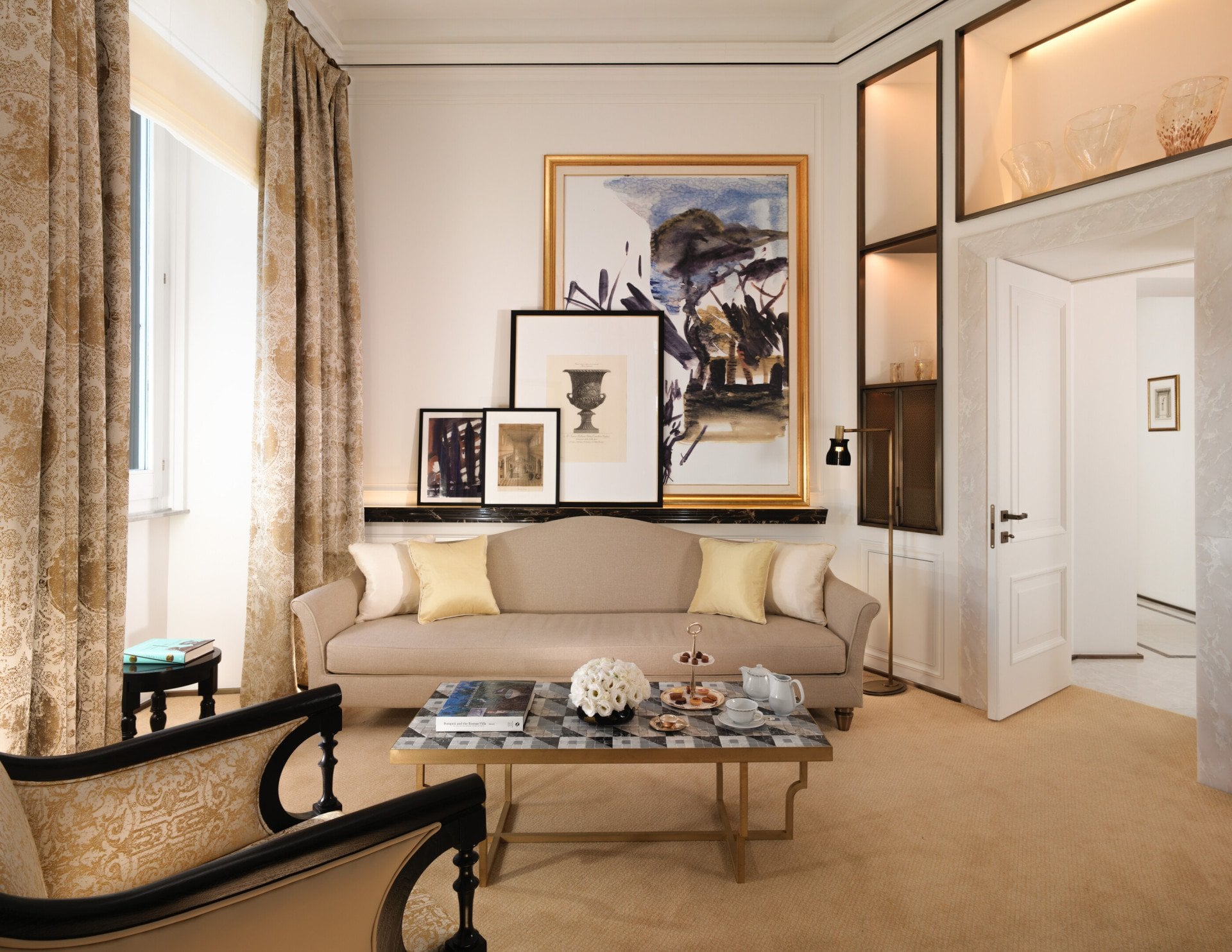 Classic suite living room with beige couch, living table and paintings on the wall 