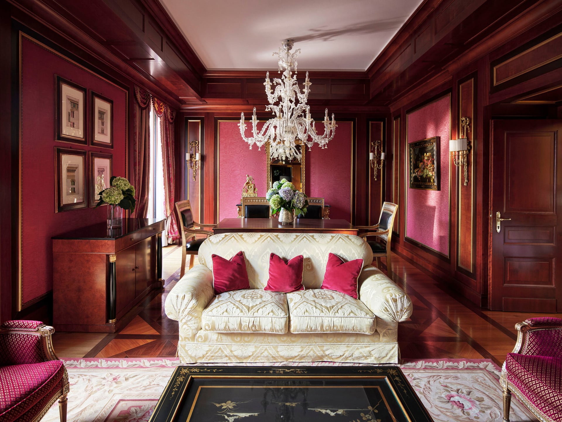 Royal Suite Living Room Overview revealing a predominantly red décor and a contrasting white sofa in the foreground