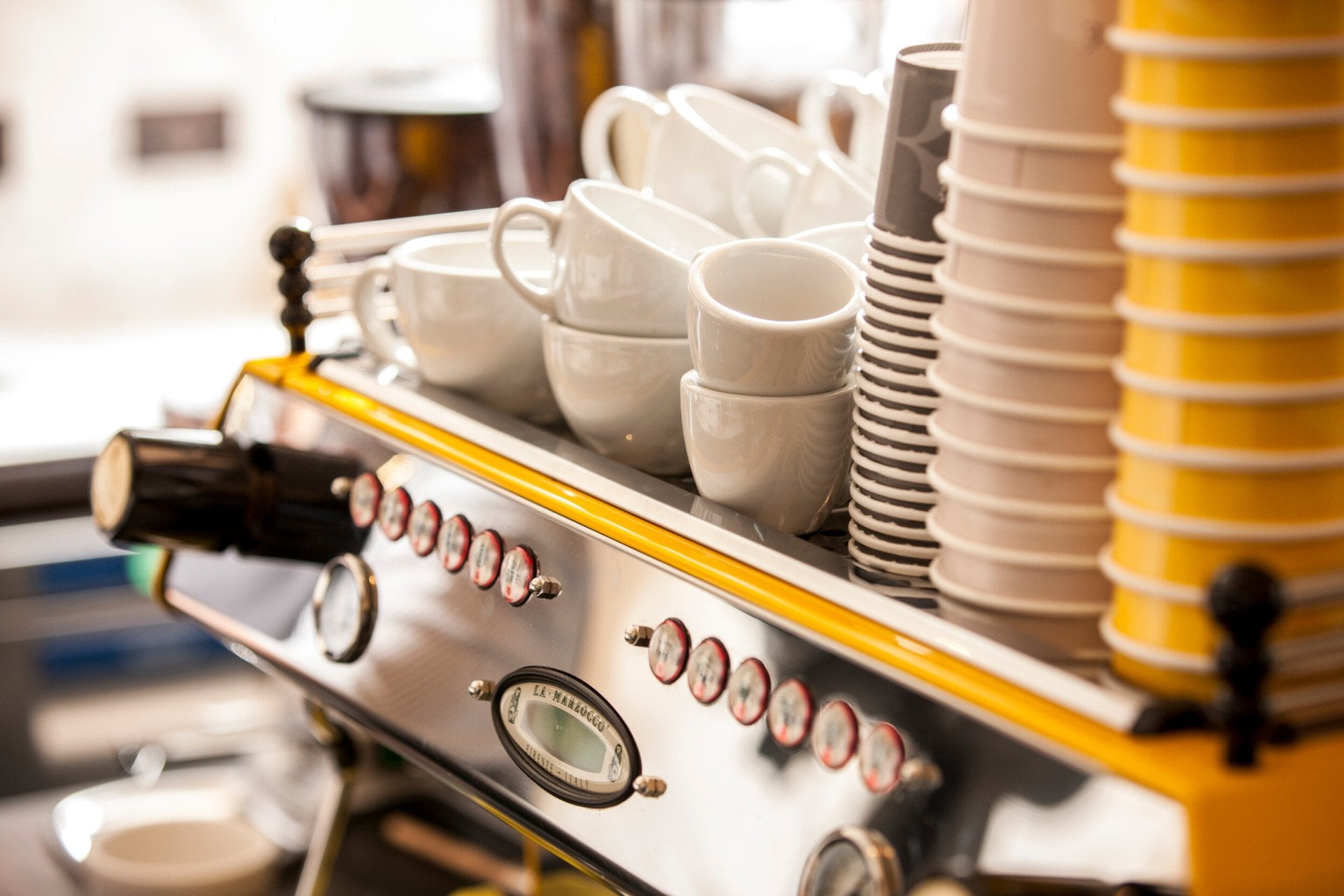 Close-up of the coffee station at Parcafé at The Dorchester, showcasing an espresso machine topped with neatly stacked cups and saucers, ready for barista-crafted drinks.