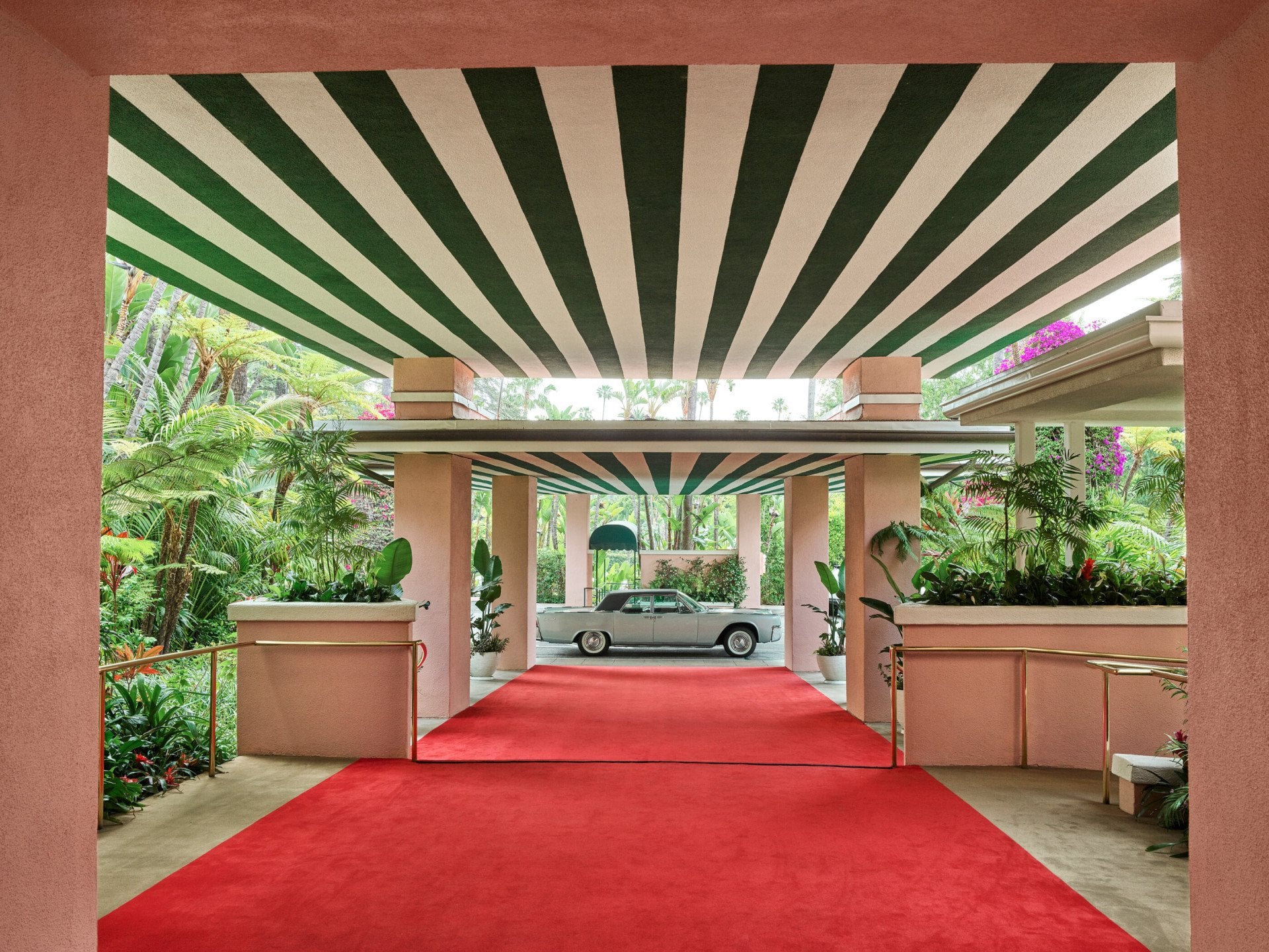 The Beverly Hills Hotel red carpet entrance facing valet direction with a blue car. 