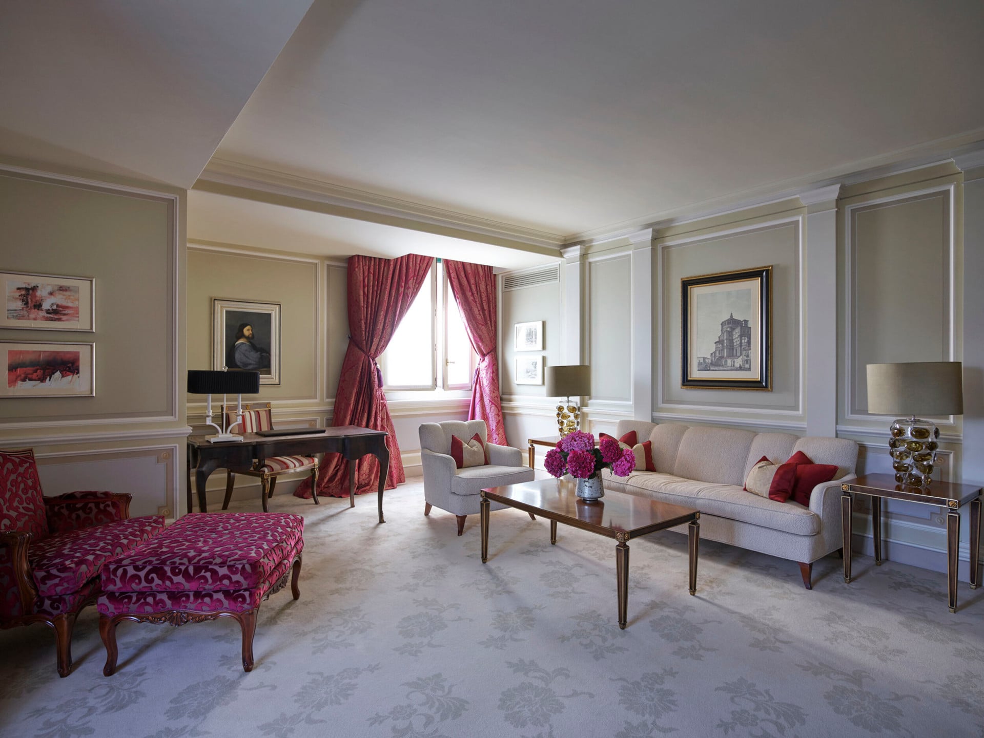 Principe Suite Living Room Overview revealing a refined décor, with touches of red and pictures hanging on the wall