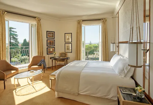 Junior Suite bedroom with windows open to view at Hotel Eden, Rome