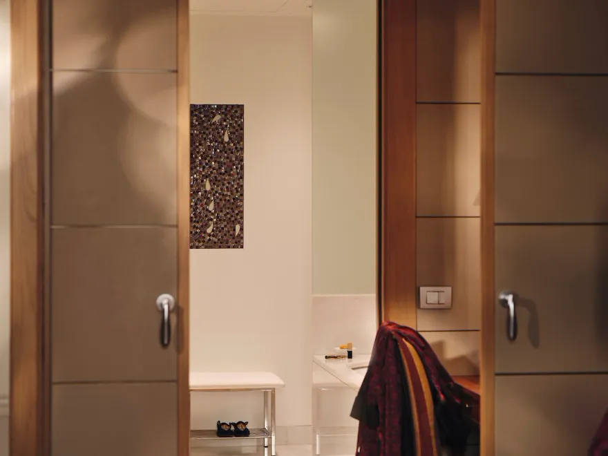 View of the bathroom from the Mosaic Room with a magazine in the foreground and a red robe in the background