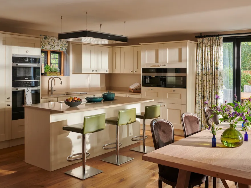 Bright kitchen with a dining area, flowers, and sliding glass doors to the garden.