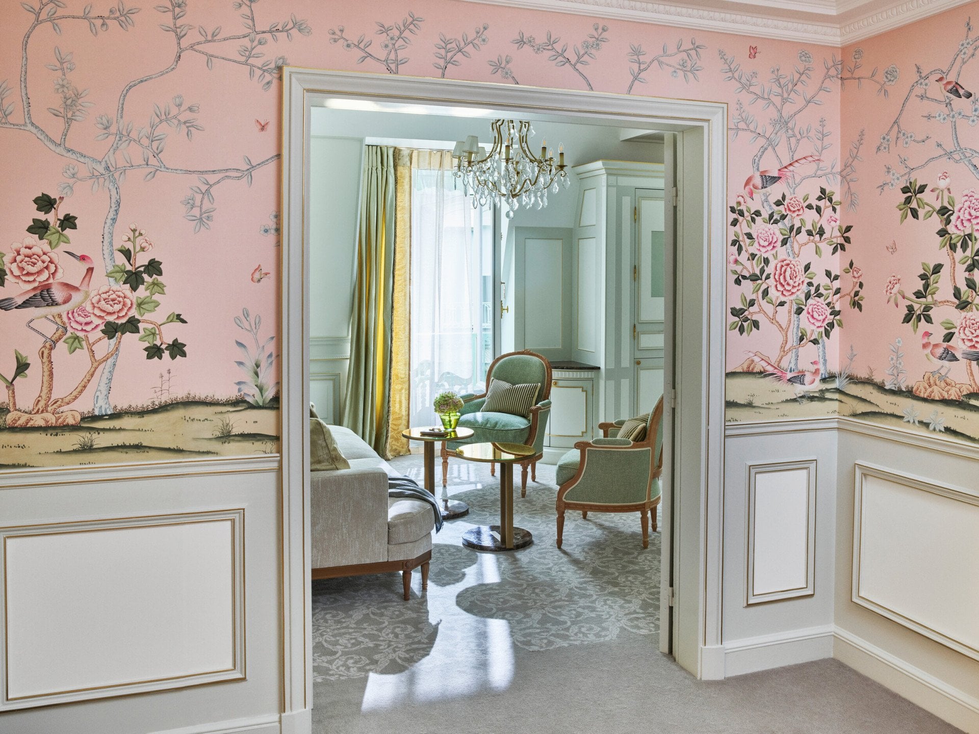Distant shot of the living room, highlighting the pink wallpaper in the room, at Le Meurice, Paris.