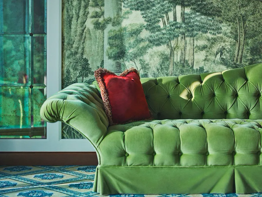 Green velvet sofa with red cushion in the second bedroom of Presidential Suite