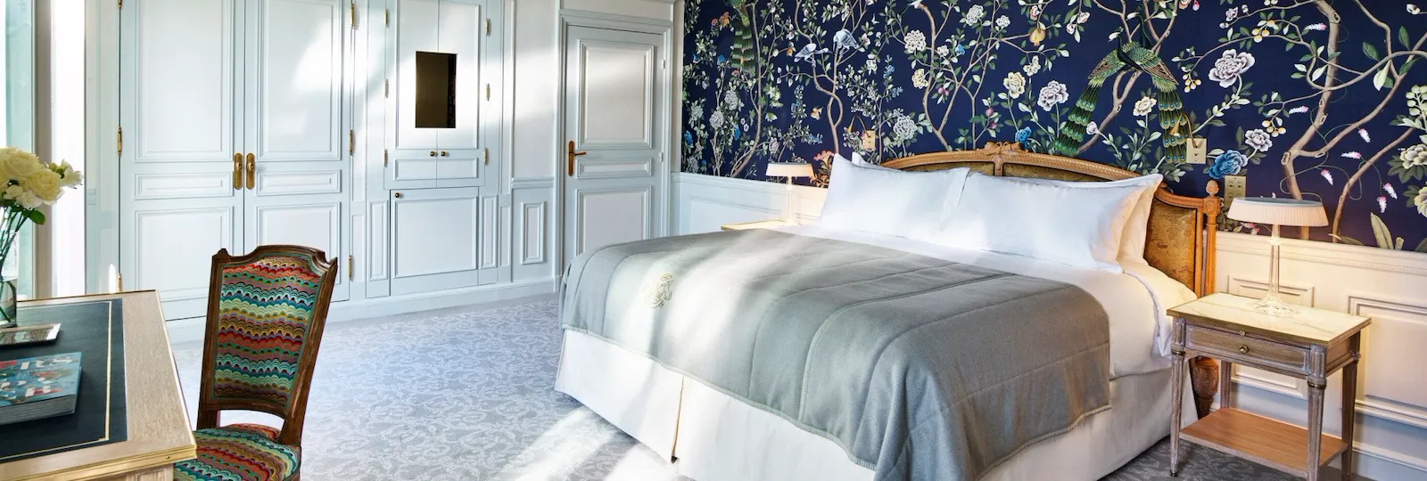 Overview of an executive room with balcony highlighting the dark blue hand painted wall with nature details. At Le Meurice, Paris.