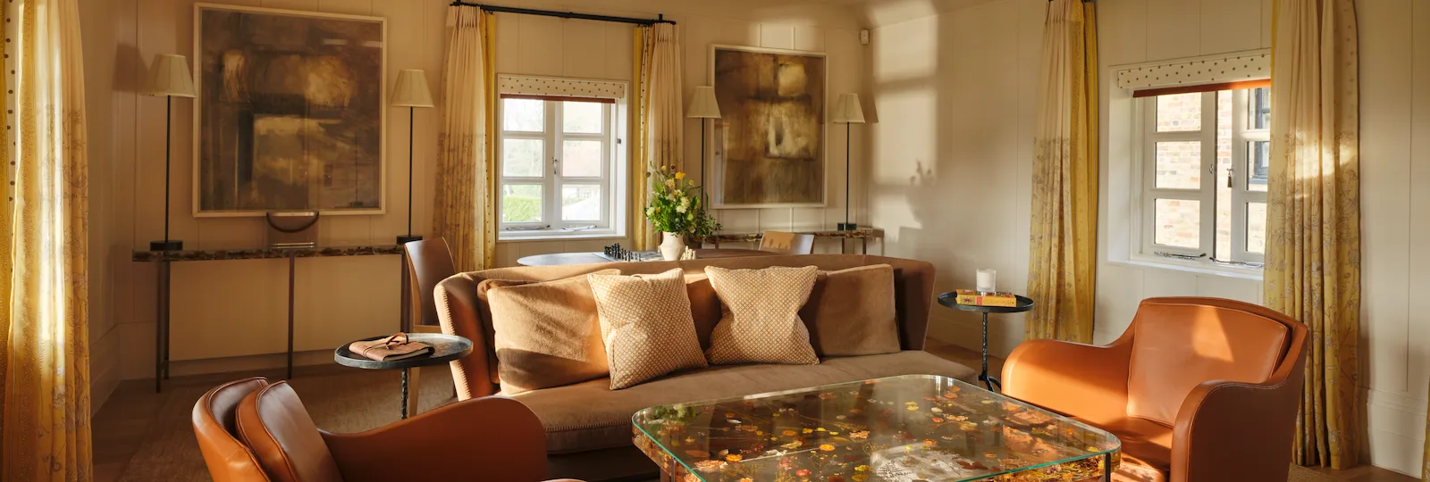 Living room with leather armchairs and decorative glass coffee table in the Gardeners suite at Coworth Park