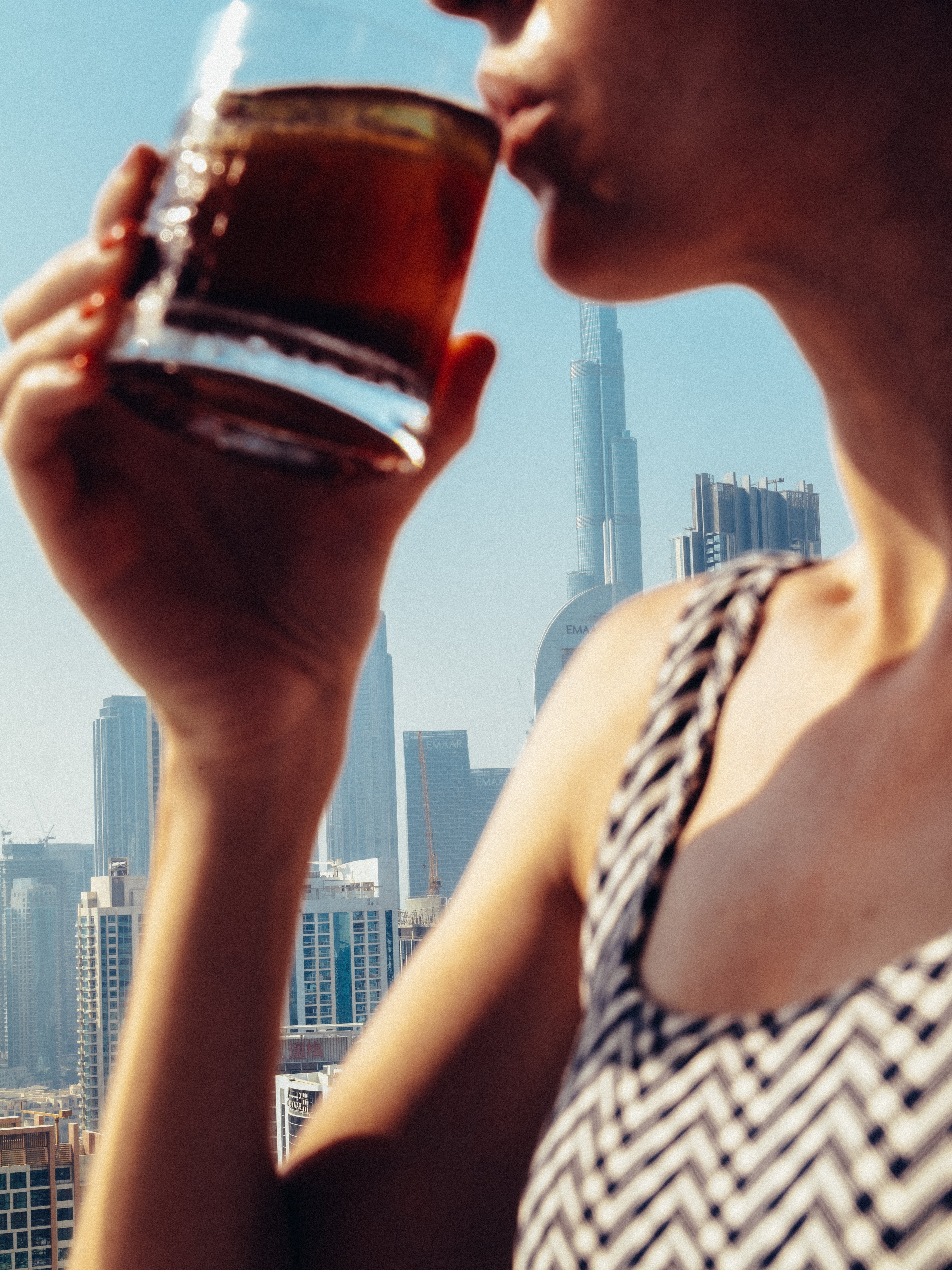 A lady sipping her drink in High Society while enjoying the skyline view