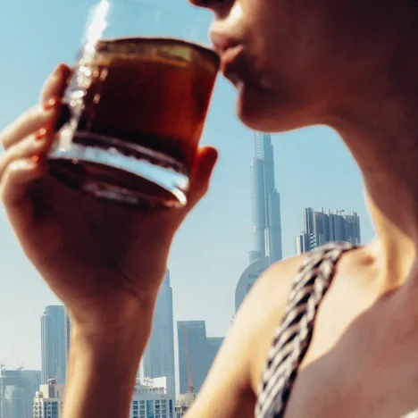 A lady sipping her drink in High Society while enjoying the skyline view