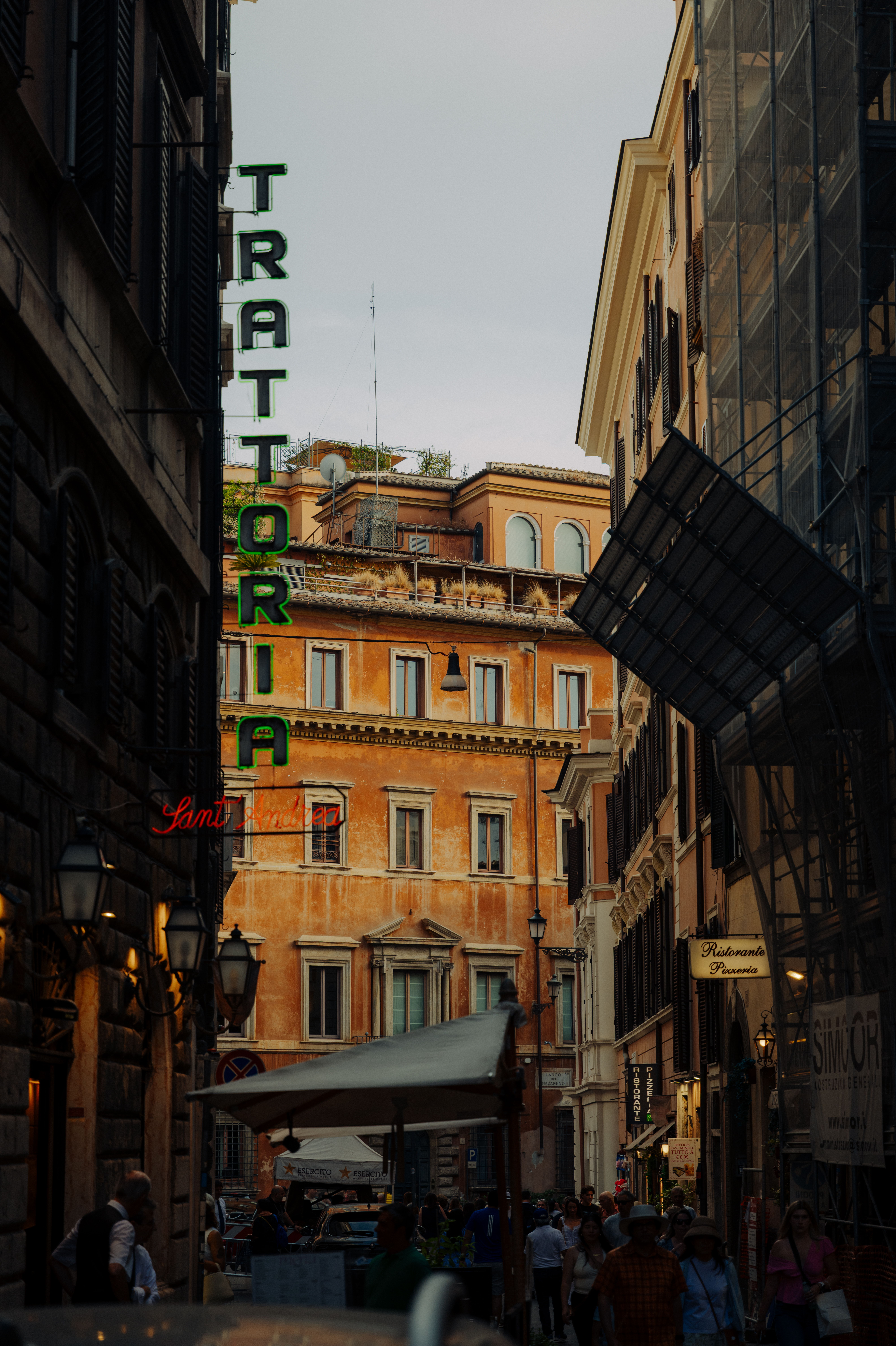 People walk through a busy city alley with signs and buildings, lively and vibrant atmosphere