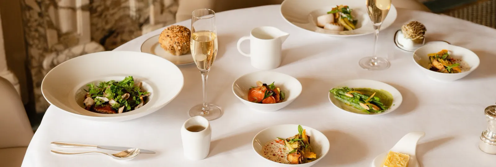 This visual shows the brunch menu of restaurant Le Meurice Alain Ducasse. There are several sweet and savory dishes on a white table cloth.