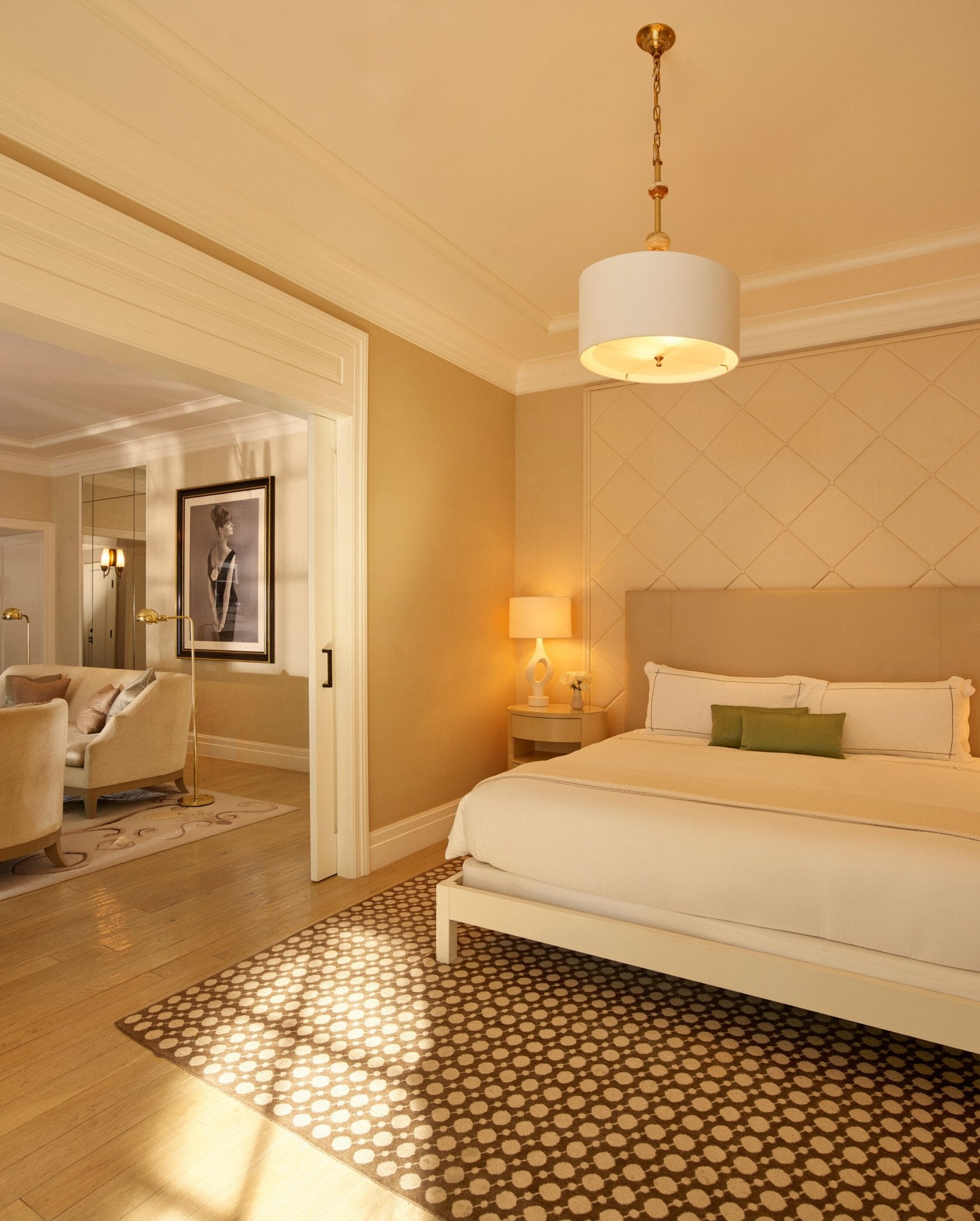 Bedroom facing the bed in the signature Grace Kelly Suite at Hotel Bel-Air with a glimpse of the adjacent Living Room area with a view of the portrait that's placed in the middle of the room. 