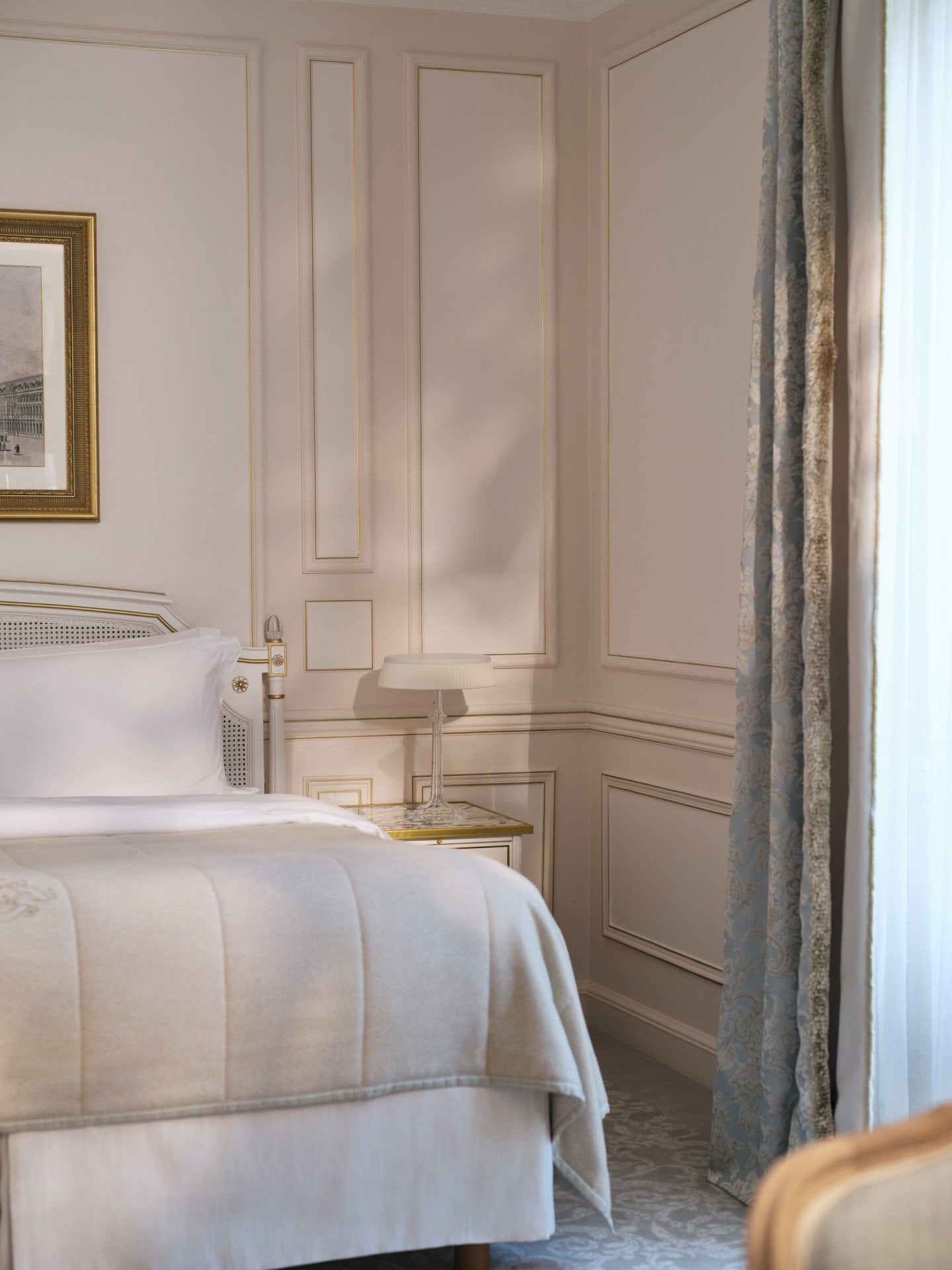 View of the left side of the bed enlighted by the window, at Le Meurice, Paris  