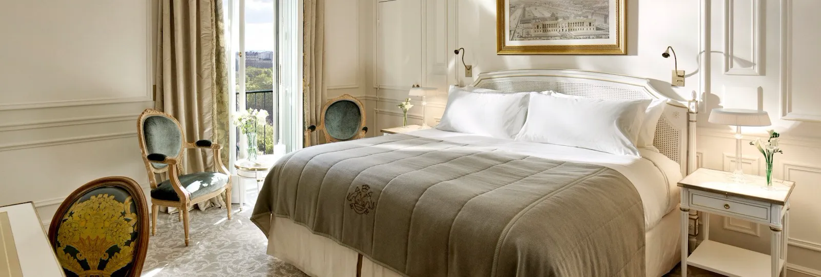 Global view of an executive room highlighting the light grey and cream undertones, as well as the view over the Tuileries gardens in the background. At Le Meurice, Paris.