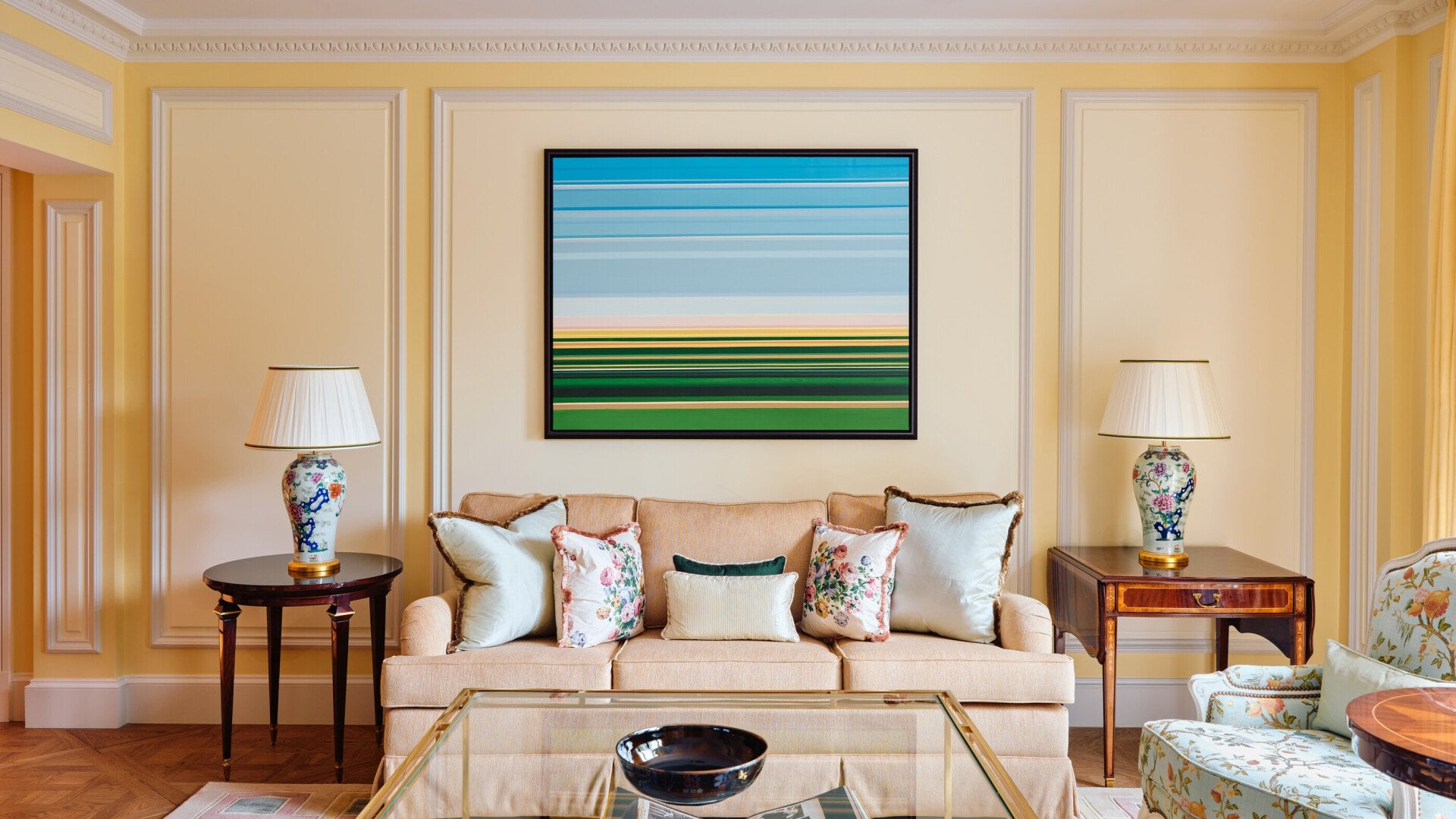 A timeless room with an attractive sofa flanked by floral lamps on elegant tables